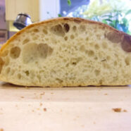 Not flipped loaf has large holes on the top, small holes on the bottom, and holes against the crust.